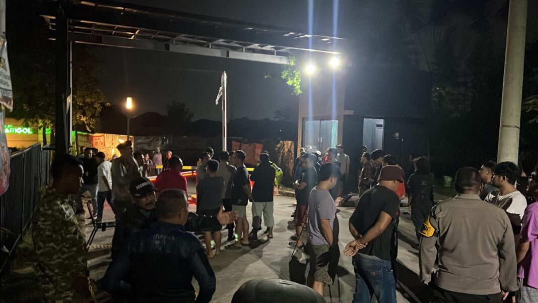 Kericuhan Vila Rizki Insaani - massa dan petugas keamanan berkumpul di portal akses Perumahan Vila Rizki Insaani Pagedangan yang ditutup warga penghuni malam hari